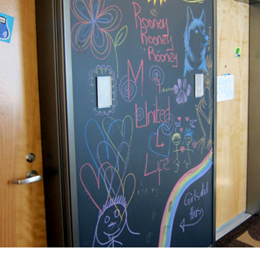 A chalkboard covered with kids' artwork